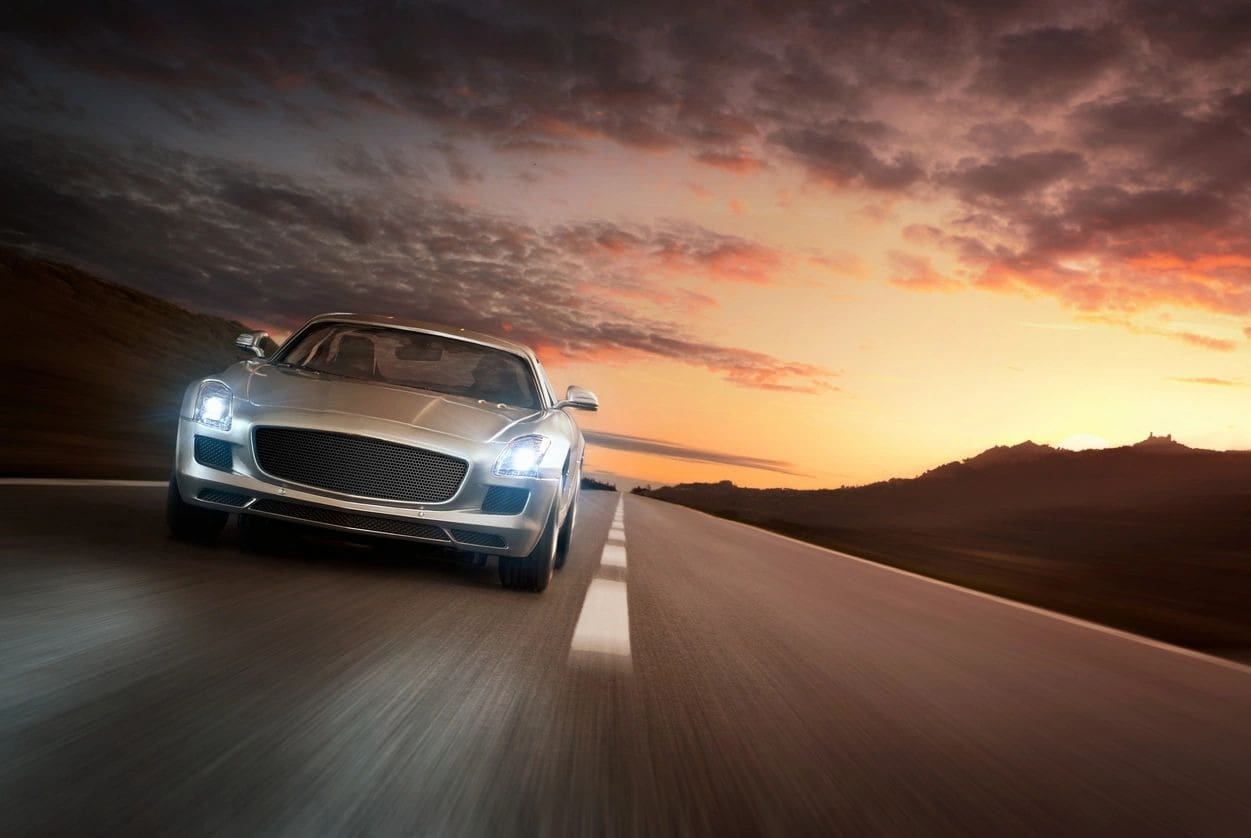 Silver sports car driving on empty highway.